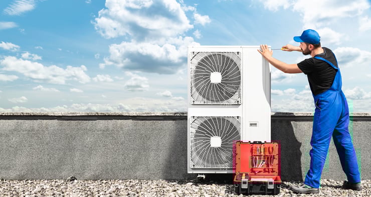 Repairman installing Air Conditioner Equipment on rooftop