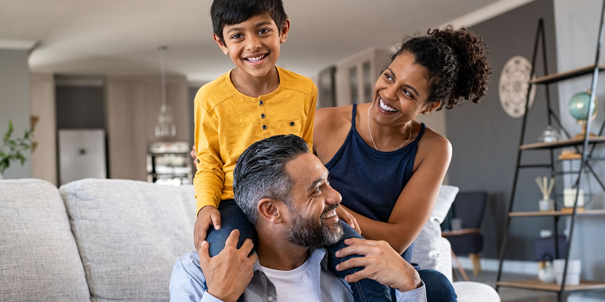 Child on fathers shoulders with mom sitting beside them