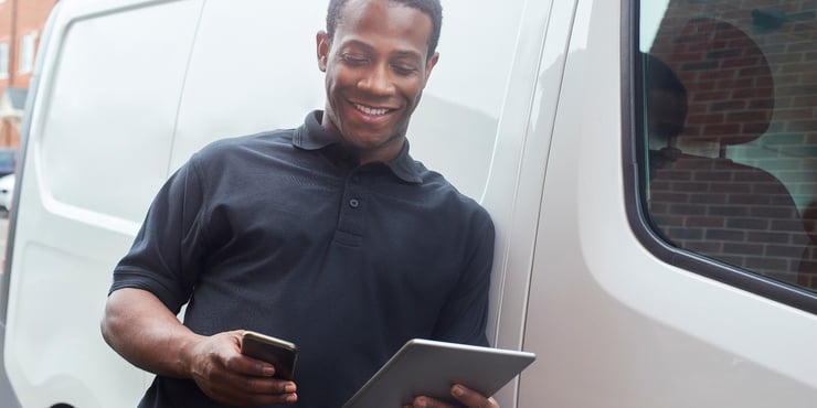 Contractor smiling down at phone reference 