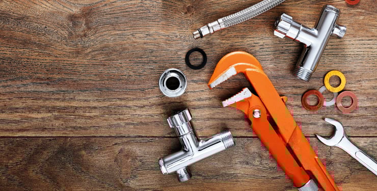 Plumbing tools on a wooden board