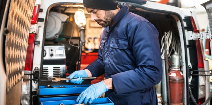Technician looking at his tools infront of van