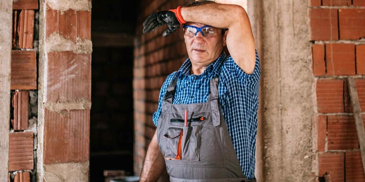 Worker wiping sweat off his forehead